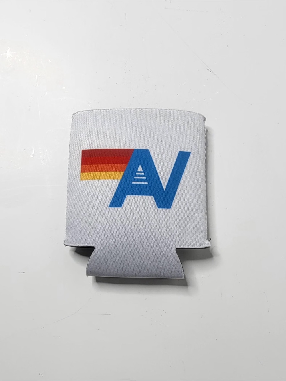 Aviador nation White Beverage Koozie with Blue 'AV' Logo and Rainbow Accent